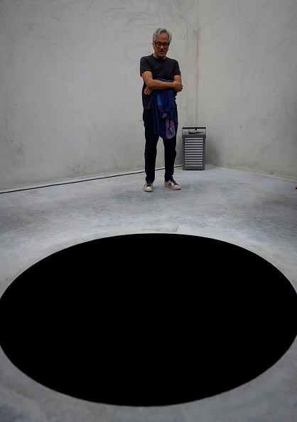 British contemporary artist Anish Kapoor stands next his artwork "Descent into limbo" during the opening of his exhibition entitled "Works, thoughts, experiments" at the Serralves Foundation in Porto, on July 6, 2018. 